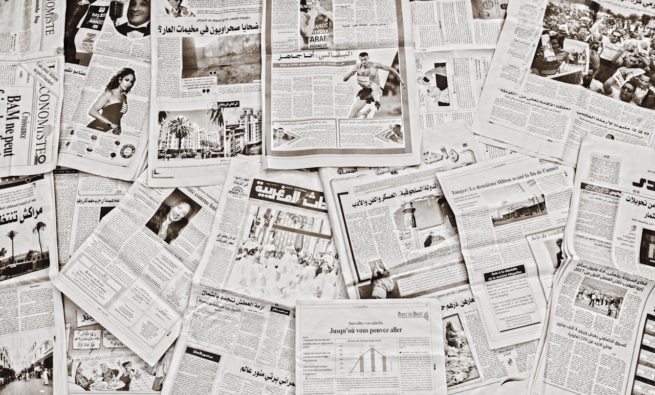 A flat lay of Arabic newspapers in Fès, Morocco, showcasing diverse articles.
