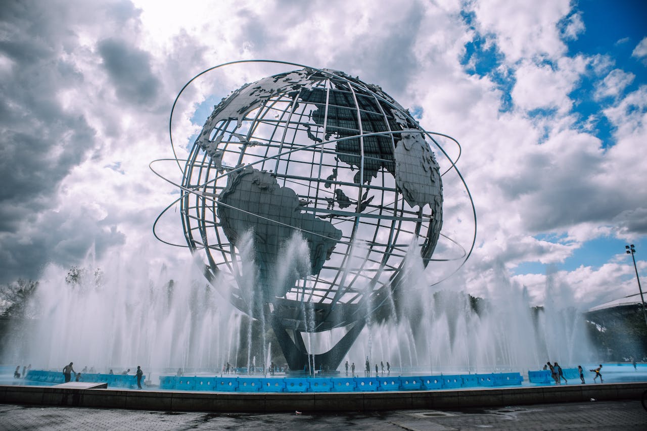 The iconic Unisphere monument in Flushing Meadows, New York, framed by a dynamic fountain display.